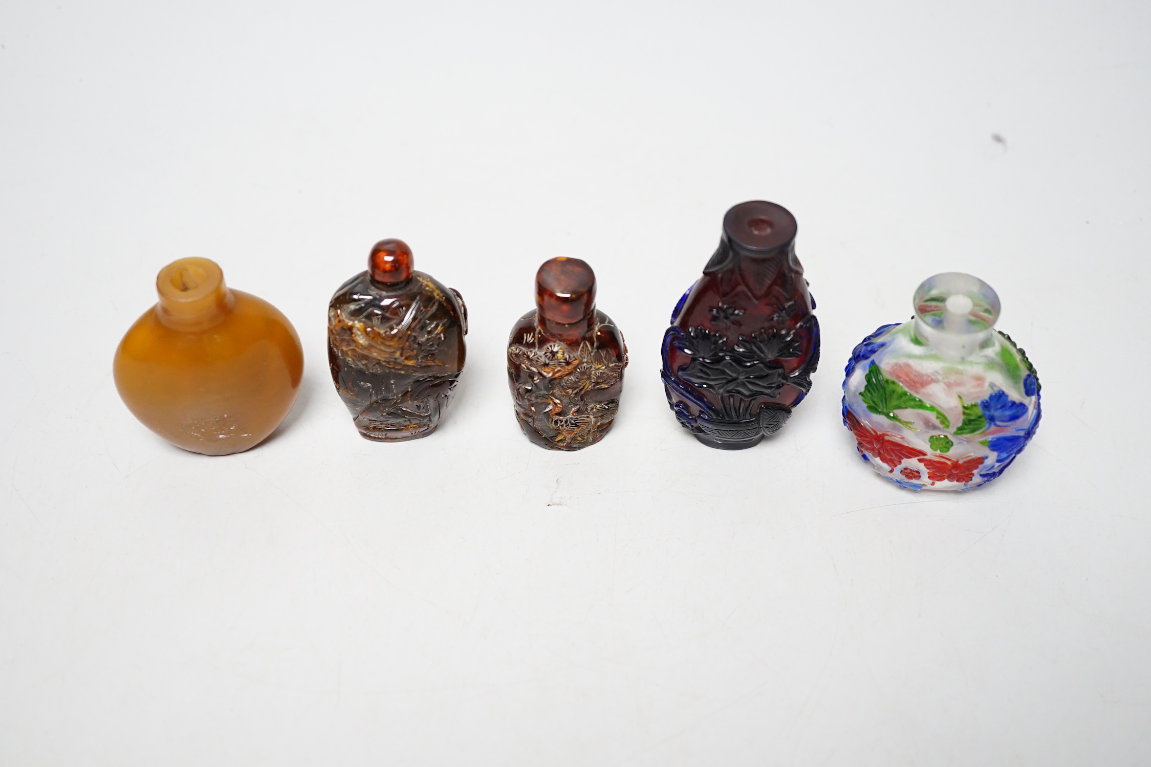 Five Chinese glass or amber snuff bottles, 7.4 cm high